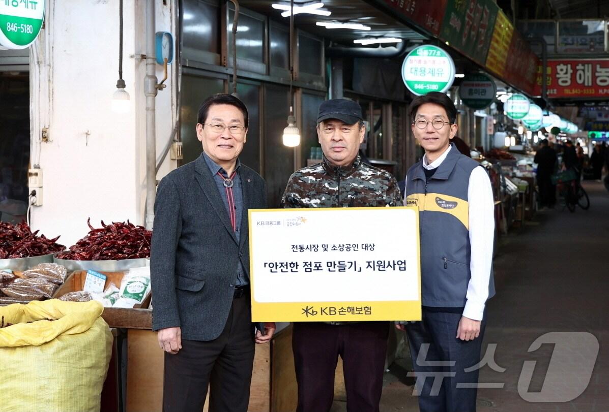 본문 이미지 - KB손해보험은 지난 18일, 경기도 의정부시에 위치한 의정부제일시장 내 소상공인 점포 10곳을 대상으로 안전점검을 실시했다. 점검 현장에서 KB손해보험 윤희승 경영전략본부장(오른쪽), 의정부제일시장 번영회 조진식 번영회장(왼쪽)이 안전점검을 받은 소상공인과 기념사진을 찍고 있다/사진제공=KB손해보험