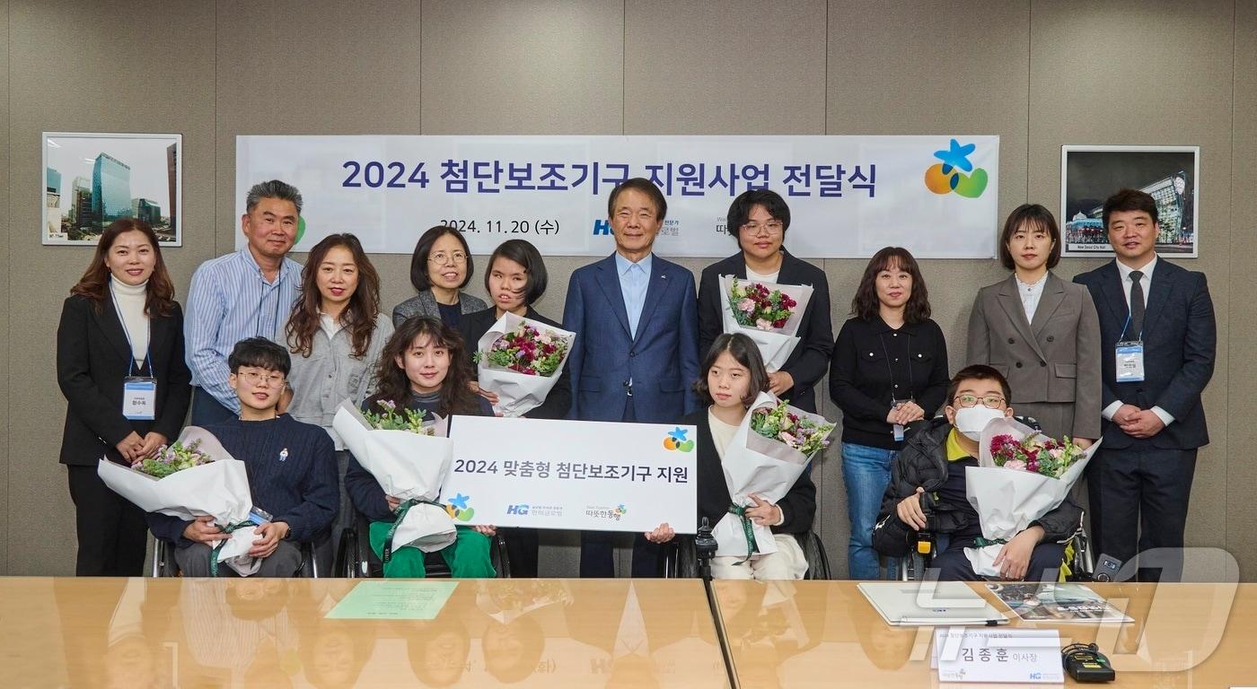 본문 이미지 - 첨단보조기구 전달식에서 따뜻한동행 관계자들과 수혜 대상자들이 기념사진을 촬영하고 있다. 뒷줄 오른쪽에서 두 번째 김두리 따뜻한동행 본부장, 다섯 번째 김종훈 이사장.(한미글로벌 제공)