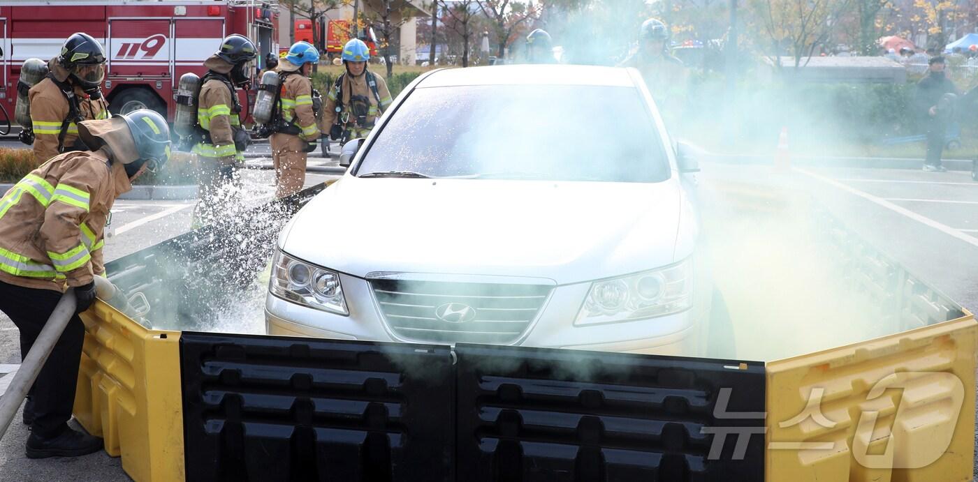 20일 전북자치도 전주시 전주팔복LH아파트 및 더메이호텔에서 열린 레디코리아(READY Korea) 4차 훈련에서 소방관들이 이동식 침수조를 이용한 전기차 화재진압 훈련을 하고 있다. 2024.11.20/뉴스1 ⓒ News1 유경석 기자