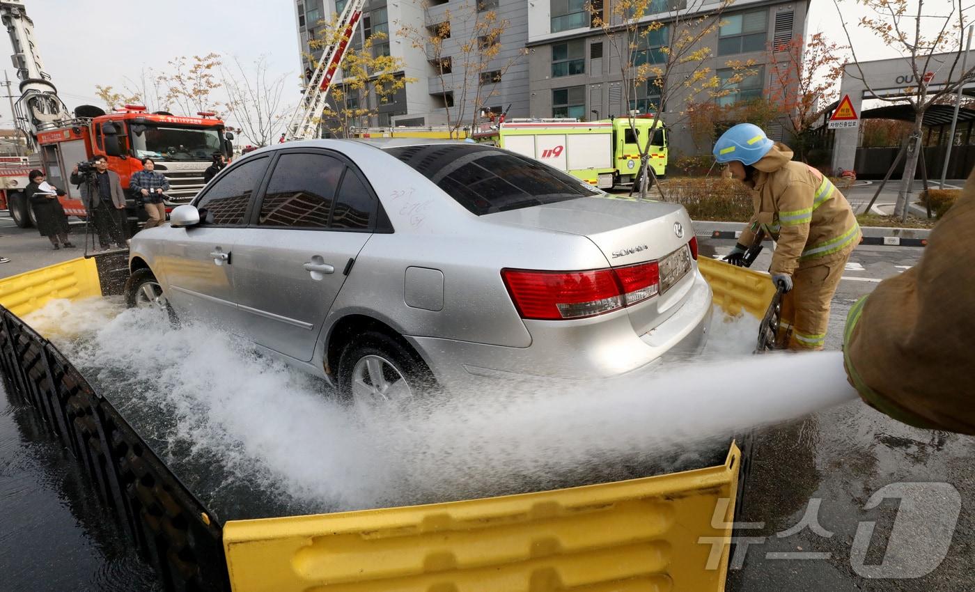 본문 이미지 - 전주시 덕진구 팔복LH아파트 및 더 메이호텔에서 행정안전부를 비롯한 전북소방본부, LH 등이 참여한 가운데 열린 유관기관합동 전기차 화재 대응 제4차 READY Korea 훈련에서 소방대원들이 화재 진압한 전기차를 이동식 소화수조에 넣고 있다. 2024,11,20 ⓒ 뉴스1 김기남 기자