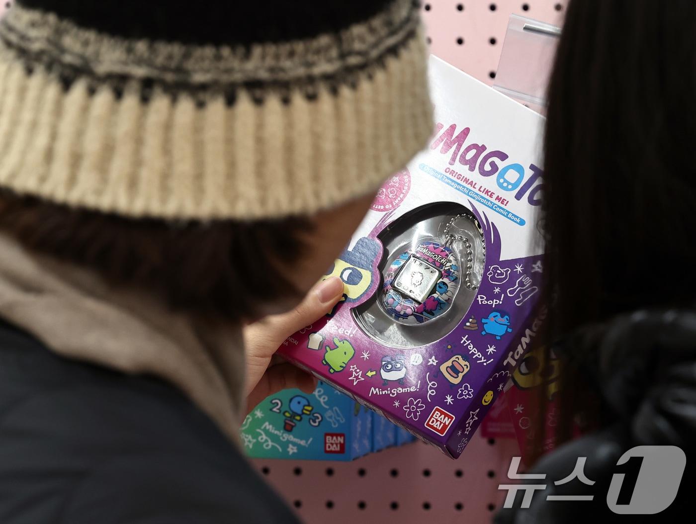 본문 이미지 - 21일 서울 성동구 성수동 토로토로 스튜디오에 문을 연 반다이남코코리아 '다마고치 팝업스토어'에서 방문객들이 '다마고치'를 살펴보고 있다. /뉴스1 ⓒ News1 구윤성 기자