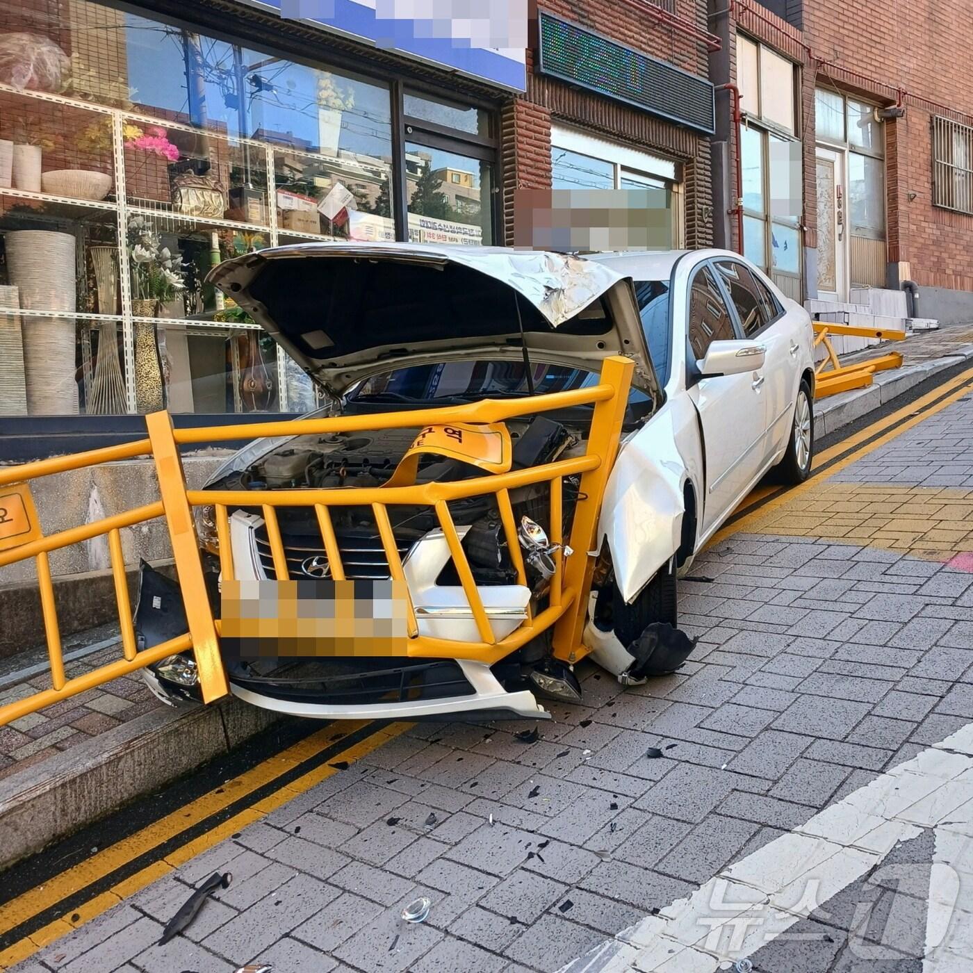 본문 이미지 - 21일 오전 부산 동구 범일동 한 초등학교 인근 스쿨존에서 승용차가 방호 울타리를 들이받아 멈춰 서 있다. (부산 동부경찰서 제공)