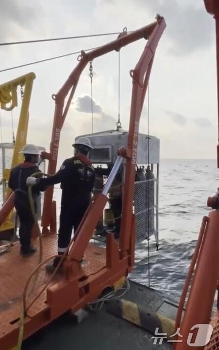 본문 이미지 - 21일 135금성호 실종자 수중수색에 나선민간 구난업체 심해잠수사들이 수중이송장비(LARS) 타고 바다로 입수하고 있다.(제주해경 제공)/뉴스1