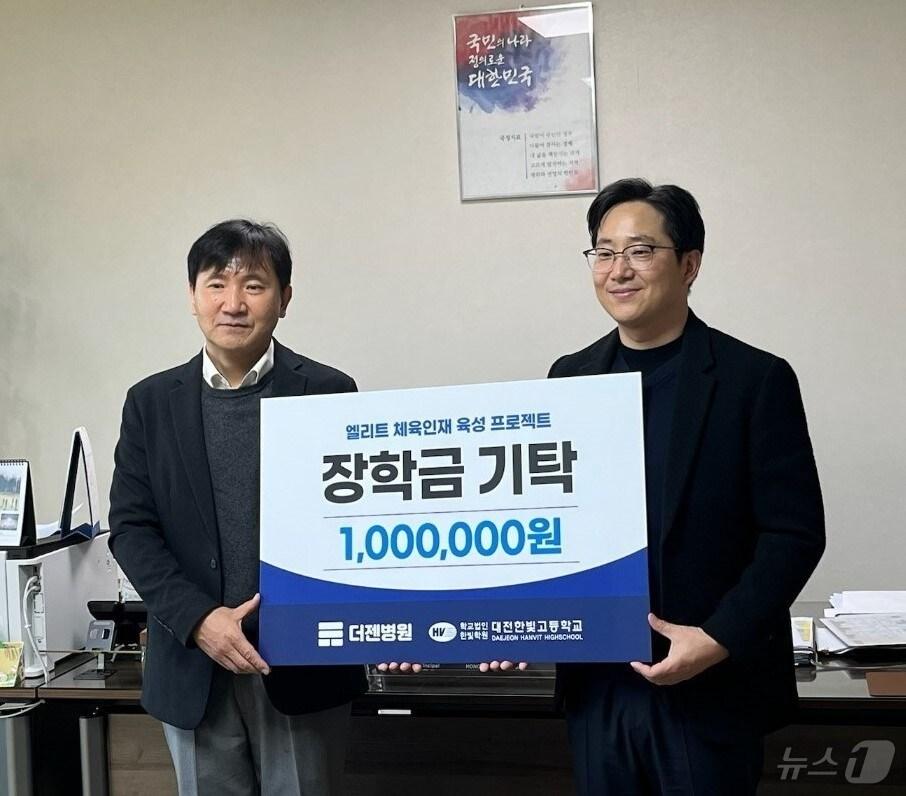 본문 이미지 -  김광선 더젠병원장(오른쪽)이 22일 대전한빛고를 찾아 홍사규 교장에게 축구부 장학금 100만 원을 전달하고 기념사진을 찍고 있다. (더젠병원 제공)/뉴스1