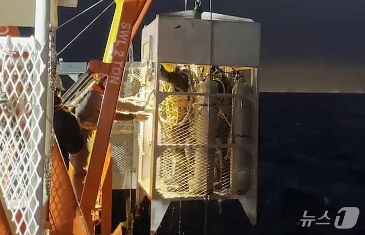 본문 이미지 - '135금성호' 침몰 사고 발생 14일째인 지난 21일 오후 민간 구난업체 심해잠수사들이 제주 비양도 해상에서 수중 수색을 마친 뒤 수중 이송장비(LARS)를 타고 출수하고 있다.(제주지방해양경찰청 제공) 2024.11.22/뉴스1