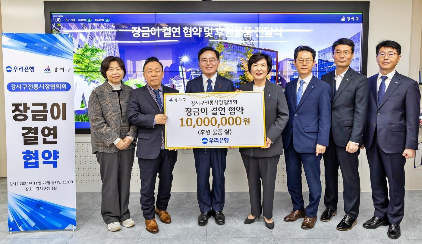 우리은행은 22일 강서구청에서 강서구 소재 6개 전통시장과 장금이 결연을 체결했다. 진교훈 강서구청장(왼쪽 세번째), 김호현 강서구 전통시장협의회 회장(왼쪽 두번째), 정현옥 우리은행 금융소비자보호그룹장(왼쪽 네번째)이 기념촬영을 하고 있다. 사진은 우리은행 제공.