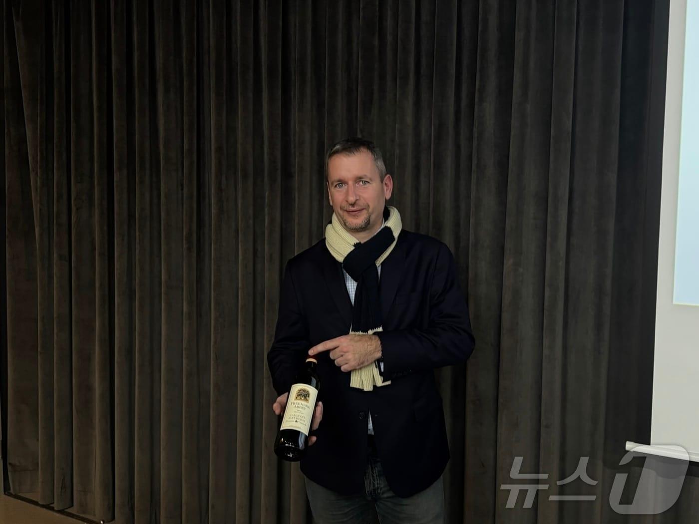 본문 이미지 - 마스터 소믈리에 드미트리 메나르가 '프리마크 아비 카베르네 소비뇽'을 들고 웃고 있다.2024.11.21/뉴스1 ⓒ News1 이강 기자