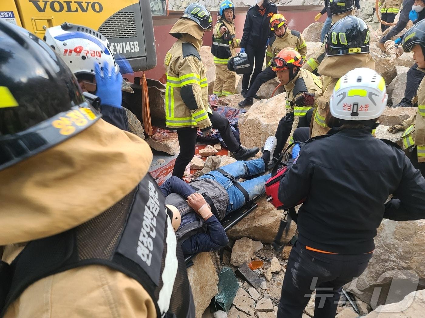본문 이미지 - 23일 오후 4시 22분쯤 전남 여수시 신덕동의 한 야적장 공사 현장에서 석축 작업을 하고 있던 포클레인이 넘어져 작업자들이 깔리는 사고가 발생했다. 사진은 소방당국이 구조하는 모습.(전남 여수소방서 제공) 2024.11.23/뉴스1
