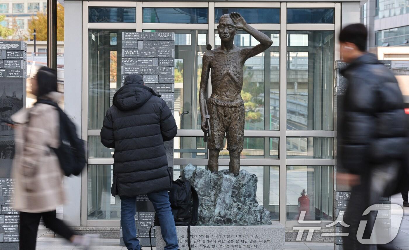 본문 이미지 - 24일 오후 서울 용산역 광장 강제징용노동자상 앞으로 시민들이 지나가고 있다. 우리 정부는 사도광산 추도식에 대한 일본 정부의 진정성이 부족하다고 판단해 불참을 통보했다. 불참 배경으로는 일본 정부 대표로 참석할 예정인 이쿠이나 아키코 외무성 정무관(차관급)의 야스쿠니 신사 참배 이력이 결정적이었던 것으로 전해졌다. 2024.11.24/뉴스1 ⓒ News1 장수영 기자