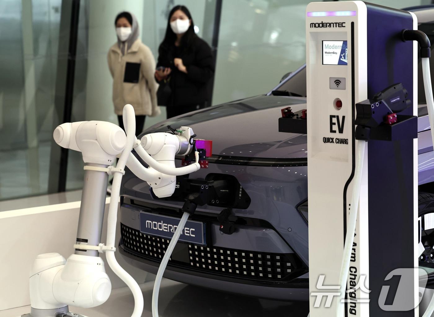 본문 이미지 - 25일 서울 동대문디자인플라자&#40;DDP&#41; 아트홀에서 열린 &#39;2024 서울 기후테크 컨퍼런스&#39;에서 참관객들이 전기차 충전 로봇의 시연을 보고 있다. 2024.11.25/뉴스1 ⓒ News1 구윤성 기자