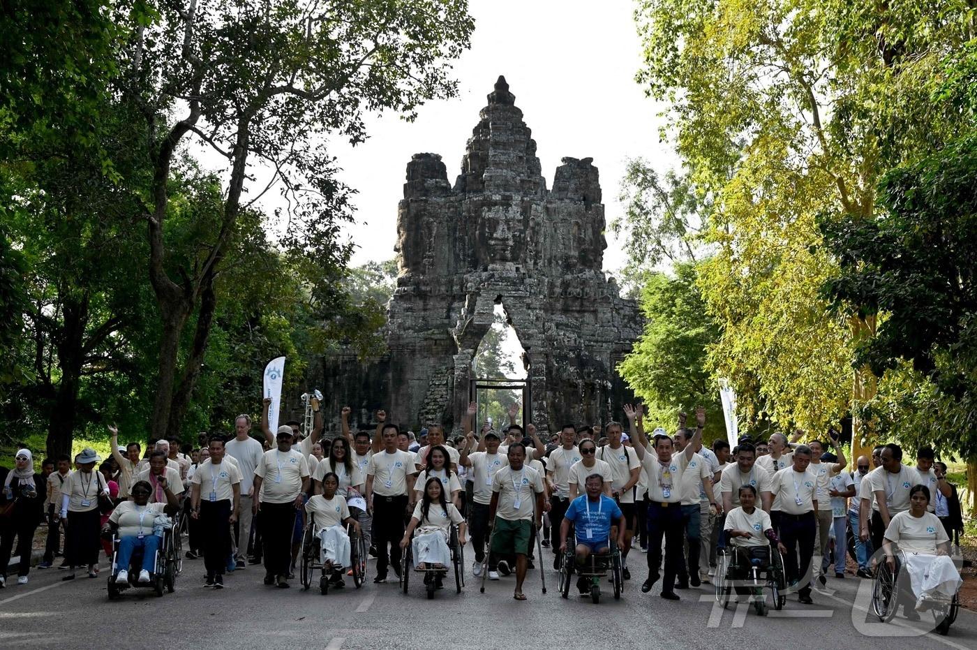 본문 이미지 - 2024년 11월 24일(현지시간) 캄보디아 시엠레아프주 앙코르 톰 남문에서 지뢰 없는 세상을 위한 콘퍼런스 행사 일환으로 지뢰 피해자들과 운동가들이 행진하고 있다. 2024.11.24/ ⓒ AFP=뉴스1