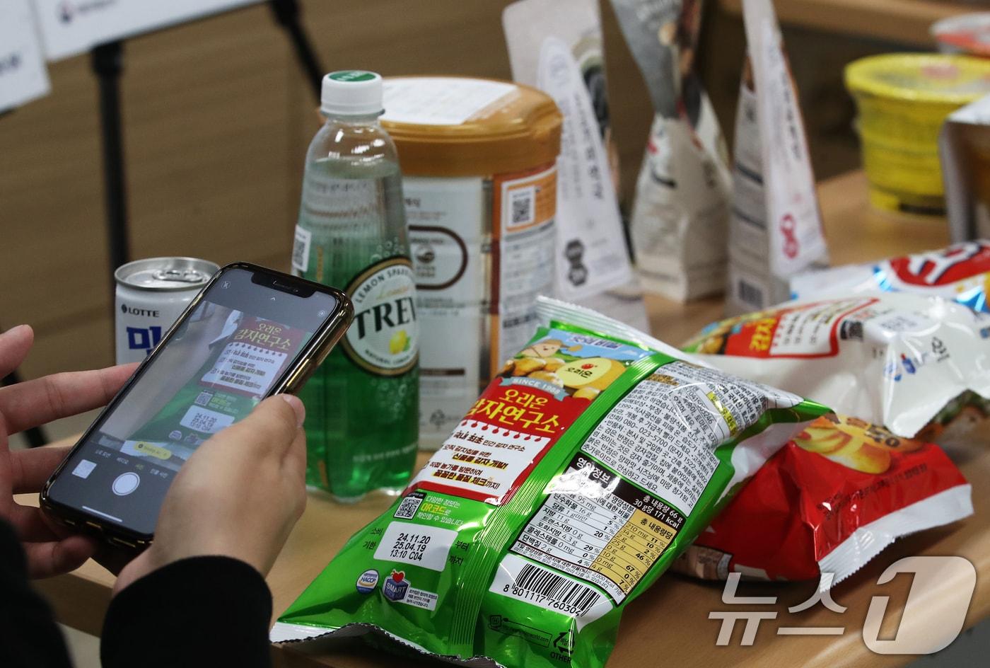 식품의약품안전처 관계자가 26일 서울 양천구 서울지방식약청에서 열린 ‘푸드QR 표시 제품 출시’ 브리핑에서 실시간 식품 정보 확인을 위한 푸드QR 서비스를 시연하고 있다.  2024.11.26/뉴스1 ⓒ News1 오대일 기자