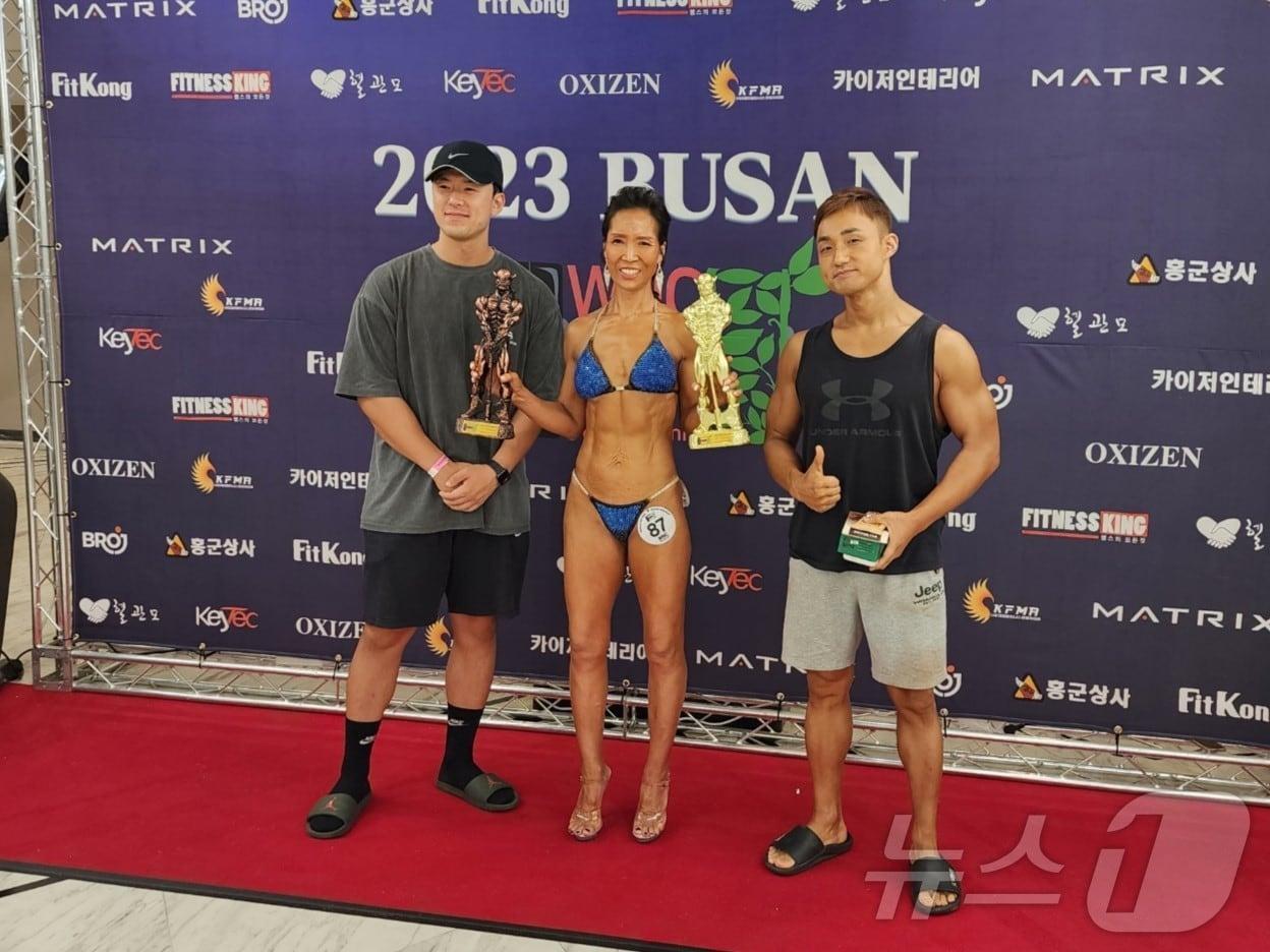 본문 이미지 - 박향자씨가 WNC 부산 비키니 시니어 종목 1등을 수상하고 기념사진을 찍고 있다.&#40;동남권원자력의학원 제공&#41;