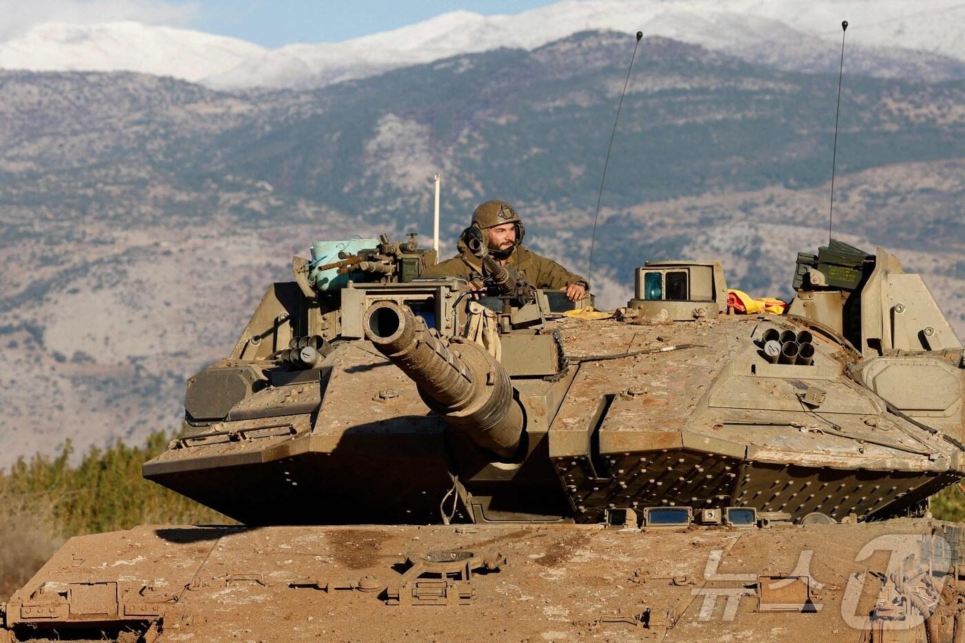 본문 이미지 - 26일 (현지시간) 레바논 접경인 어퍼 갈릴리에서 헤즈볼라와 전쟁 중인 이스라엘 군 병사가 탱크를 타고 경계를 하고 있다. <자료 사진> 2024.11.27 ⓒ AFP=뉴스1 ⓒ News1 우동명 기자