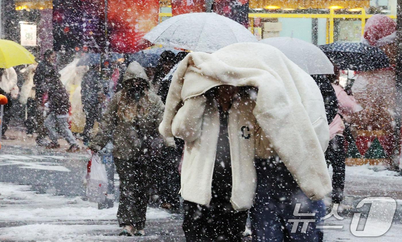 본문 이미지 - 많은 눈이 내린 27일 오후 서울 명동에서 관광객들이 발걸음을 재촉하고 있다. 기상청은 기상관측을 시작한 이래 11월 가장 많은 눈이 내렸다고 밝혔다. 2024.11.27/뉴스1 ⓒ News1 장수영 기자