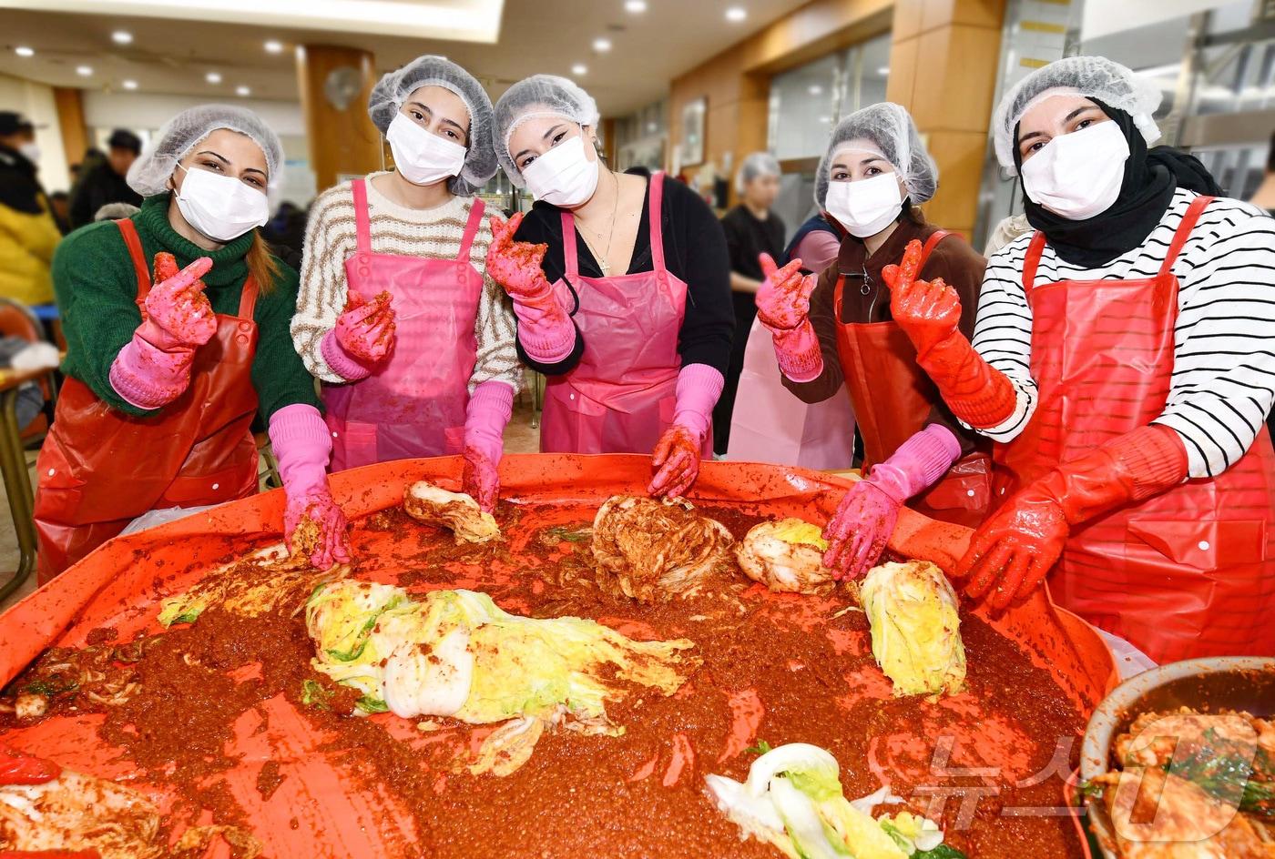 27일 김장 나눔 봉사활동에 나선 영진전문대 사회봉사단과 외국인 유학생들이 정성껏 양념을 버무리고 있다. (영진전문대 제공)