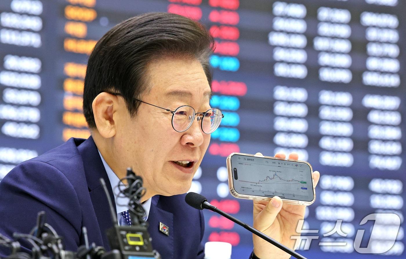 본문 이미지 - 이재명 더불어민주당 대표가 28일 오전 서울 여의도 한국거래소 홍보관에서 열린 대한민국 주식시장 활성화TF 현장 간담회 중 최근 주가가 급등하며 투자주의종목으로 지정됐었던 삼부토건의 주가 차트를 들어보이고 있다. 2024.11.28/뉴스1 ⓒ News1 장수영 기자