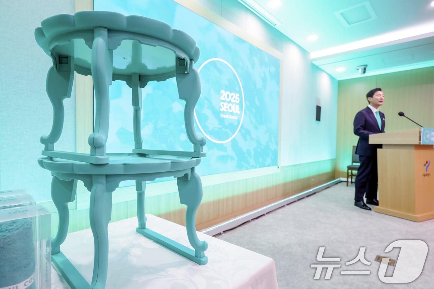 본문 이미지 - 28일 오전 서울 중구 서울시청에 2025년 서울색으로 선정된 '그린오로라(GreenAurora)'가 적용된 서울굿즈가 오세훈 시장 옆으로 전시돼 있다. 2024.11.28/뉴스1 ⓒ News1 민경석 기자