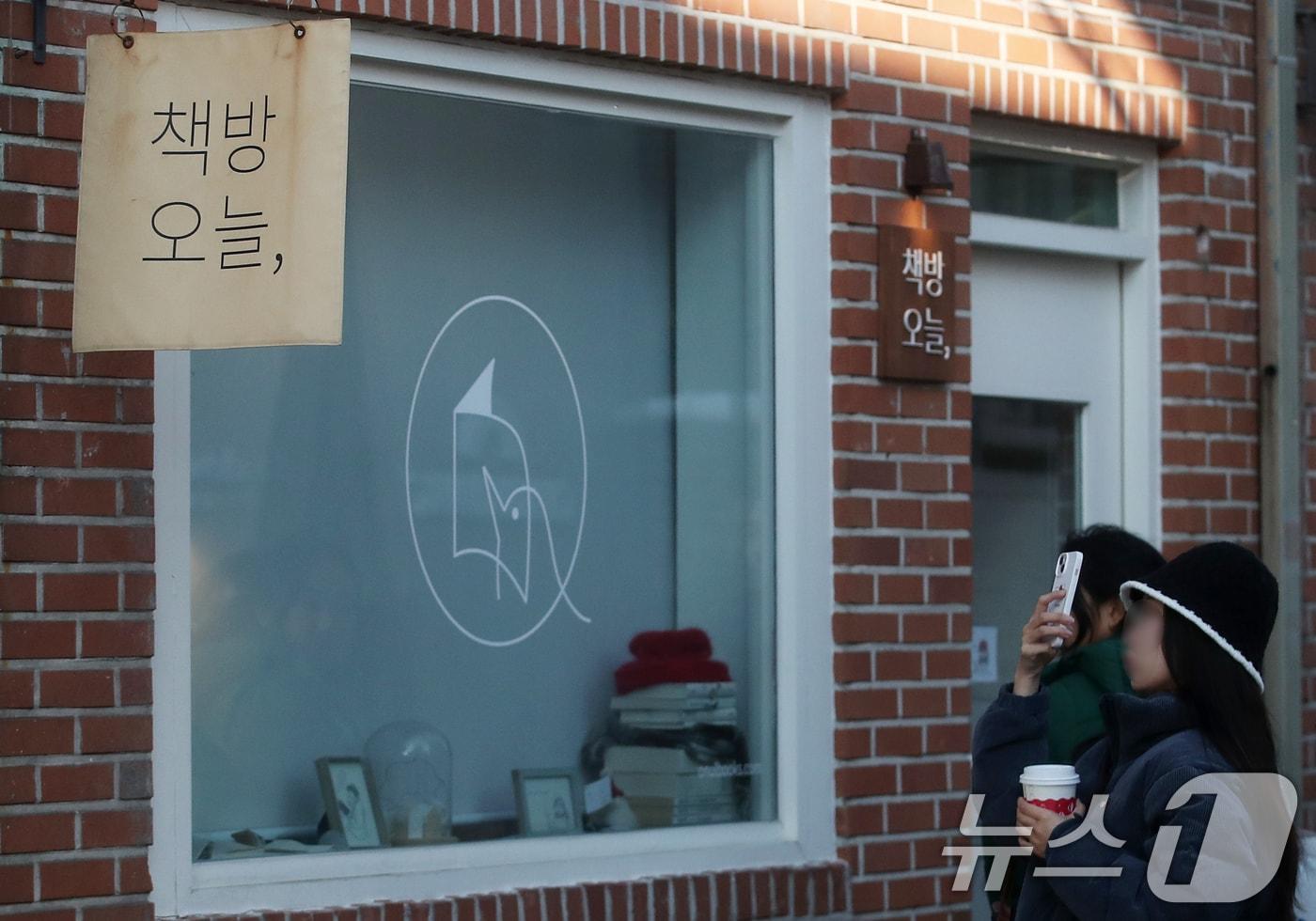본문 이미지 - 서울 종로구 통의동 독립서점 '책방오늘'을 찾은 시민들이 스마트폰으로 인증샷을 남기는 모습. 2024.11.28 ⓒ 뉴스1 오대일 기자