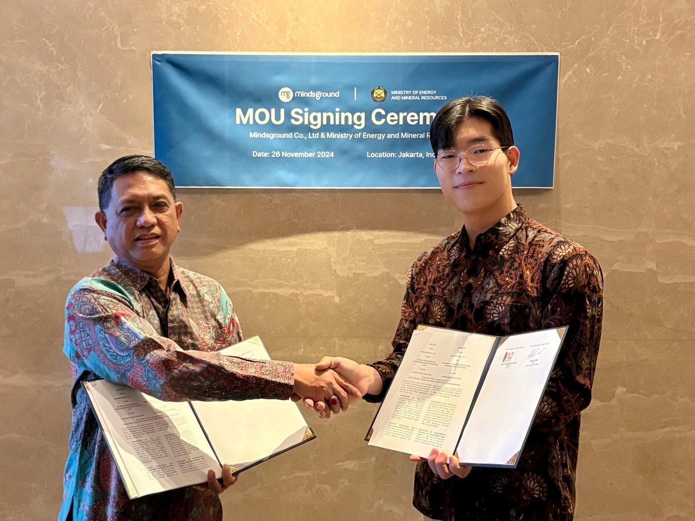 본문 이미지 - 최근 자카르타 쉐라톤 호텔에서 열린 협약식에서 센다 후르무잔 카남(Senda Hurmuzan Kanam) 인도네시아 에너지광물부 국장(왼쪽)과 민환기 마인즈그라운드 대표(오른쪽)이 인도네시아 전통 의상 '바틱'을 입고 협약을 체결한 뒤 악수를 하고 있다. /사진제공 = 마인즈그라운드