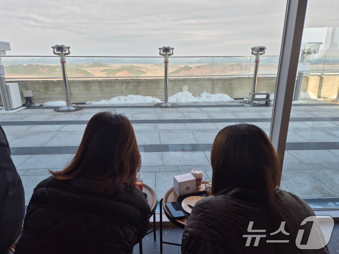 본문 이미지 - 29일 경기 김포시 애기봉평화생태공원 조강전망대에 문을 연 스타벅스에서 방문객들이 북한을 바라보고 있다. 애기봉평화생태공원은 북한 개풍군과 불과 1.4㎞ 떨어진 곳에 있는 접경지이다. 2024.11.29/뉴스1 ⓒ News1 이시명 기자