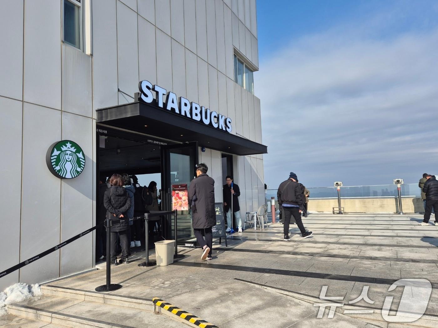 본문 이미지 - 29일 경기 김포시 애기봉평화생태공원 조강전망대에 문을 연 스타벅스에서 방문객들이 북한을 바라보고 있다. 애기봉평화생태공원은 북한 개풍군과 불과 1.4㎞ 떨어진 곳에 있는 접경지이다. 2024.11.29/뉴스1 ⓒ News1 이시명 기자