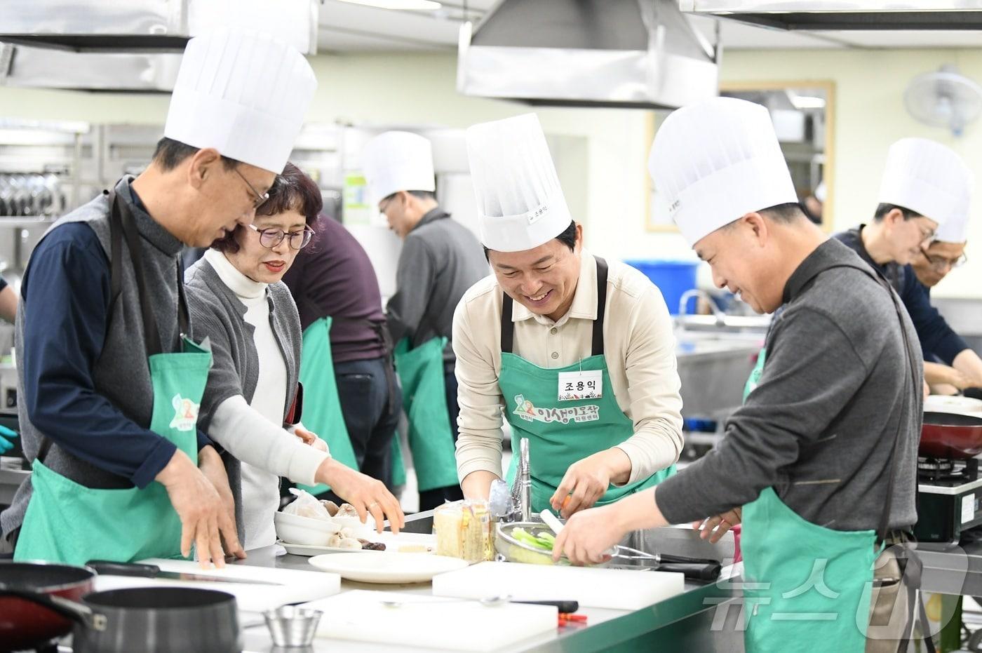 조용익 부천시장(가운데)이 인생이모작지원센터에서 운영하는 '행복을 요리하는 남자' 수업에 참여해 수강생들과 음식을 만들고 있다.(부천시 제공) / 뉴스1