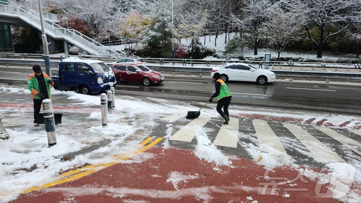 본문 이미지 - 30일 낮 지자체 관계자들이 인도 위에 쌓인 눈을 치우고 있다. (경기도 제공)