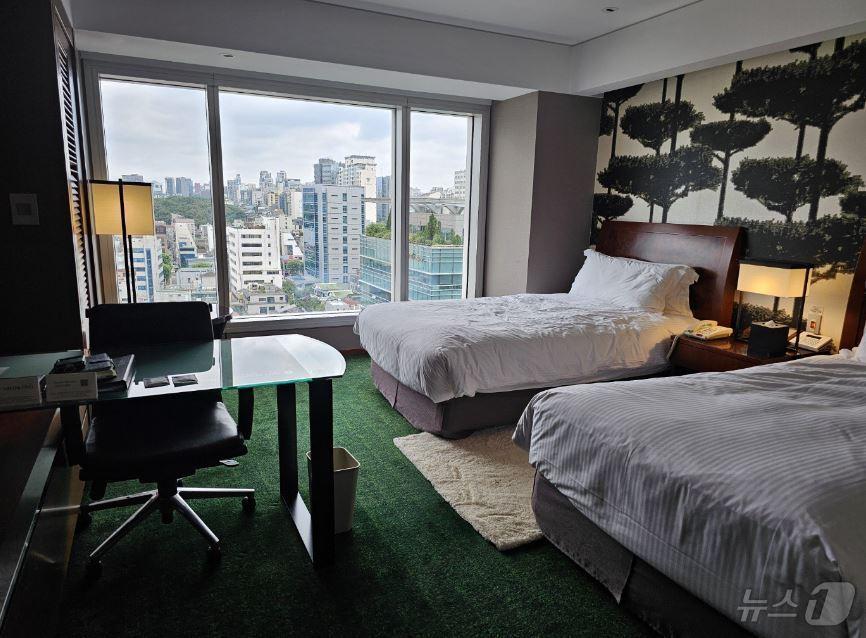 본문 이미지 -  호텔에 있는 침구류, 전등, 의자, 티비(서울시 제공)