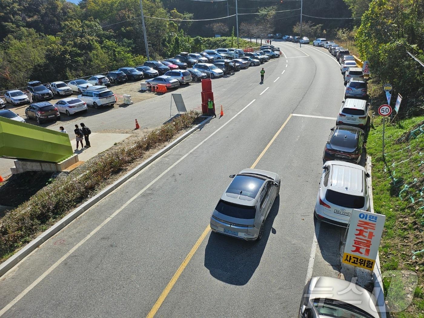 본문 이미지 -  충북 충주시 악어봉 탐방로가 개방한 지 2달 만에 탐방객 5만여 명이 몰리며 주차문제가 불거졌다. 사진은 이면도로 주차 모습.(독자 제공)2024.11.5/뉴스1