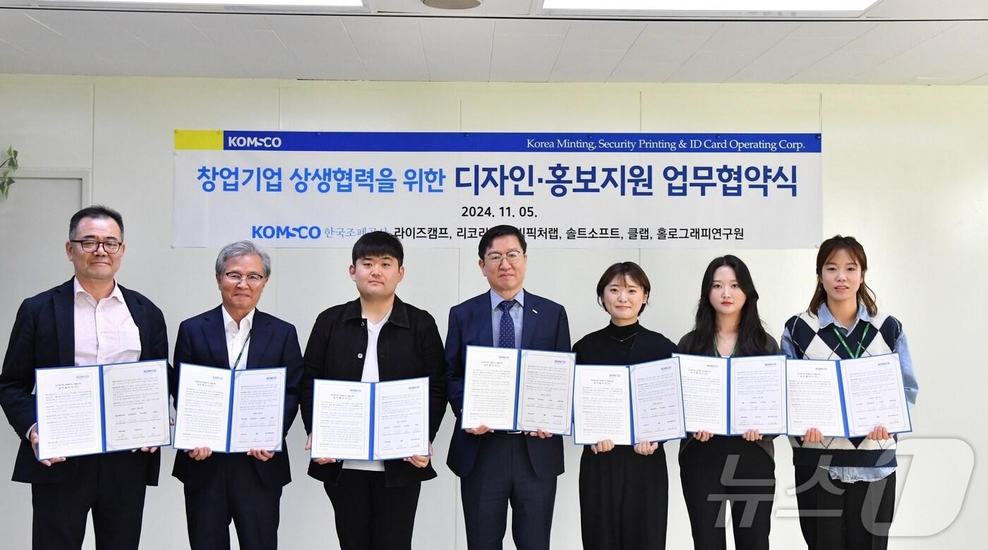 본문 이미지 - 성창훈 사장(가운데)이 공사 상생협력센터 입주 창업기업 이용일 홀로그래피연구원 대표, 이병선 ㈜빅픽처랩 대표, 김유승 솔트소프트 대표, 이주희 리코리 대표, 박수미 클랩 대표, 김선영 라이즈캠프 대표와 디자인·홍보 지원을 위한 상생협약을 체결하고 있다.(한국조폐공사 제공)/뉴스1