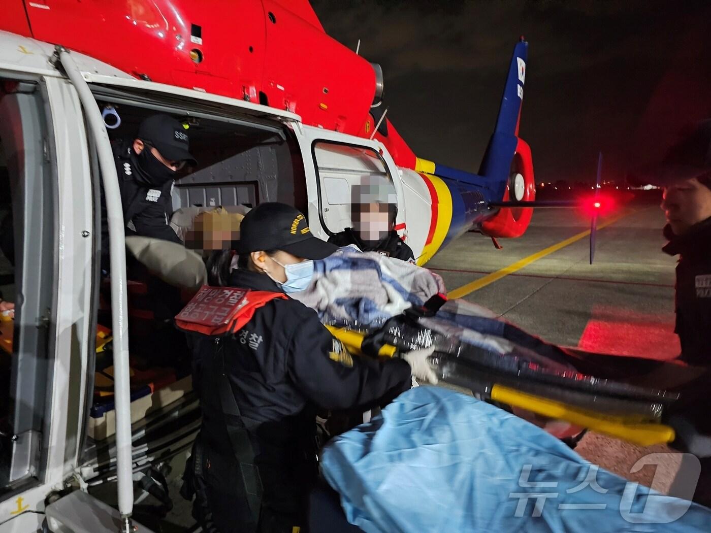 본문 이미지 - 울릉도에서 뇌출혈 의심증상을 보인 60대 응급환자를 헬기에 탑승시키는 동해해경청 소속 경찰관.(동해해경청 제공) 2024.11.5/뉴스1