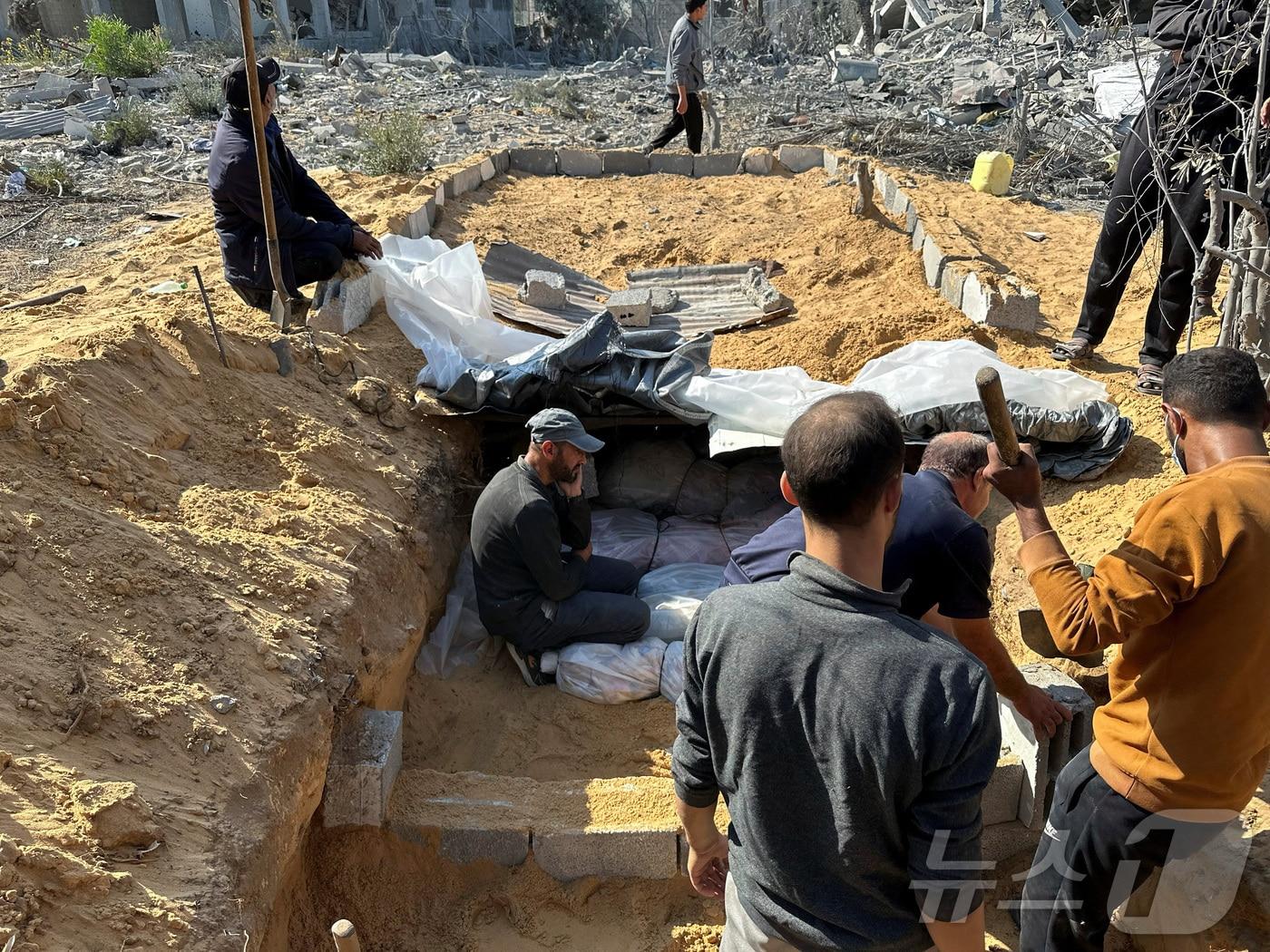 본문 이미지 - 5일(현지시간) 가자지구 북부 베이트 라히야에서 팔레스타인 주민들이 이스라엘 공습으로 사망한 희생자들의 집단 무덤을 만들고 있다. 2024.11.05/ ⓒ 로이터=뉴스1 ⓒ News1 권진영 기자