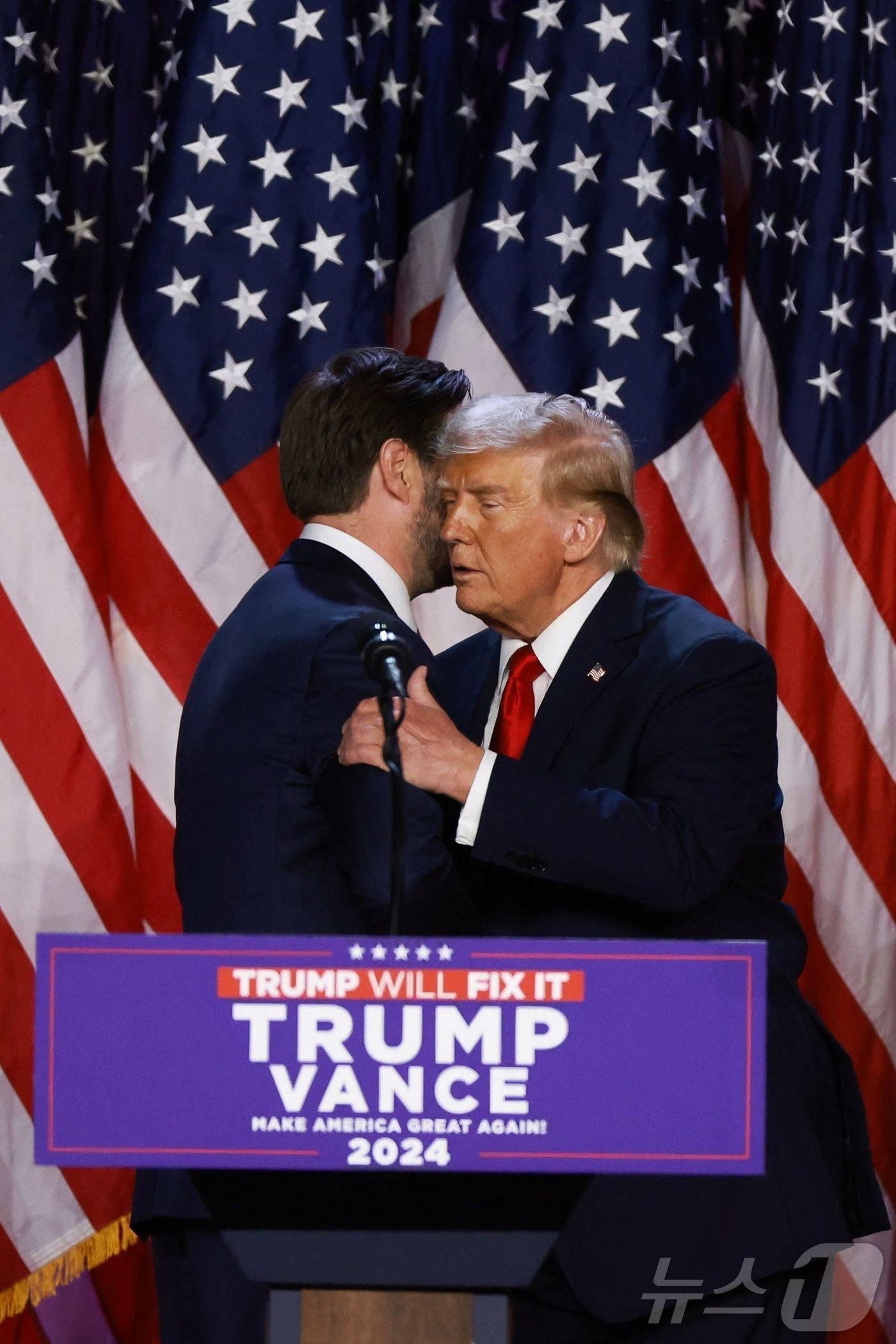 본문 이미지 - 미국 공화당 대통령 후보 도널드 트럼프 전 대통령이 6일 (현지시간) 플로리다주 웨스트 팜비치 컨벤션센터에서 열린 당선 행사서 러닝메이트인 J.D 밴스 부통령 후보와 포옹을 하고 있다. 2024.11.07 ⓒ AFP=뉴스1 ⓒ News1 우동명 기자