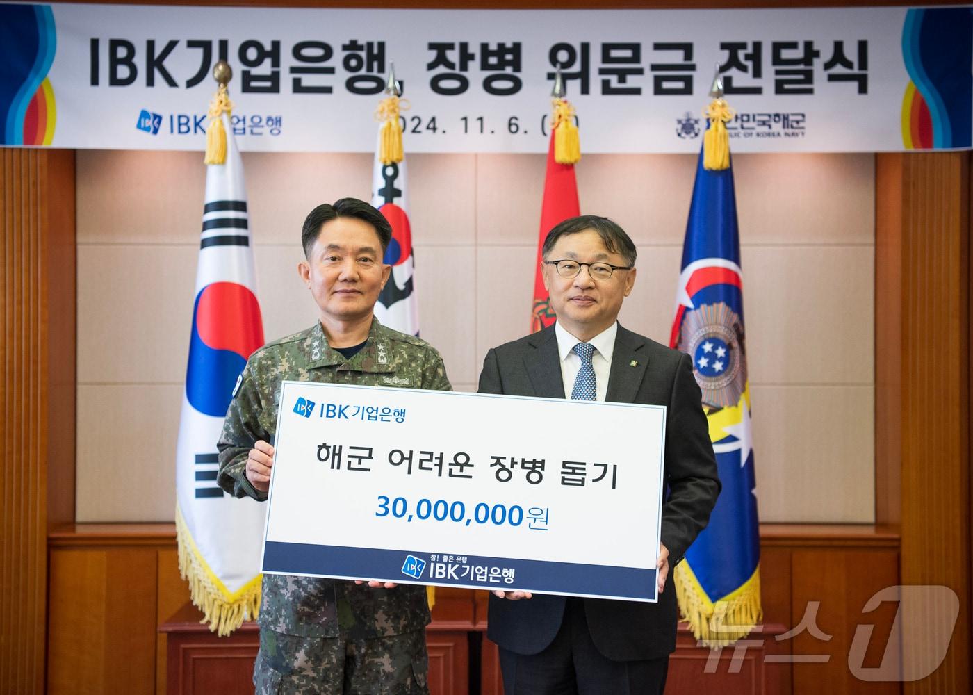 본문 이미지 - 지난 6일 해군 재경근무지원대대에서 열린 위문금 전달식에서 유일광 IBK기업은행 개인고객그룹 부행장&#40;오른쪽&#41;과 김인호 해군 인사참모부장&#40;왼쪽&#41;이 기념촬영을 하고 있다.