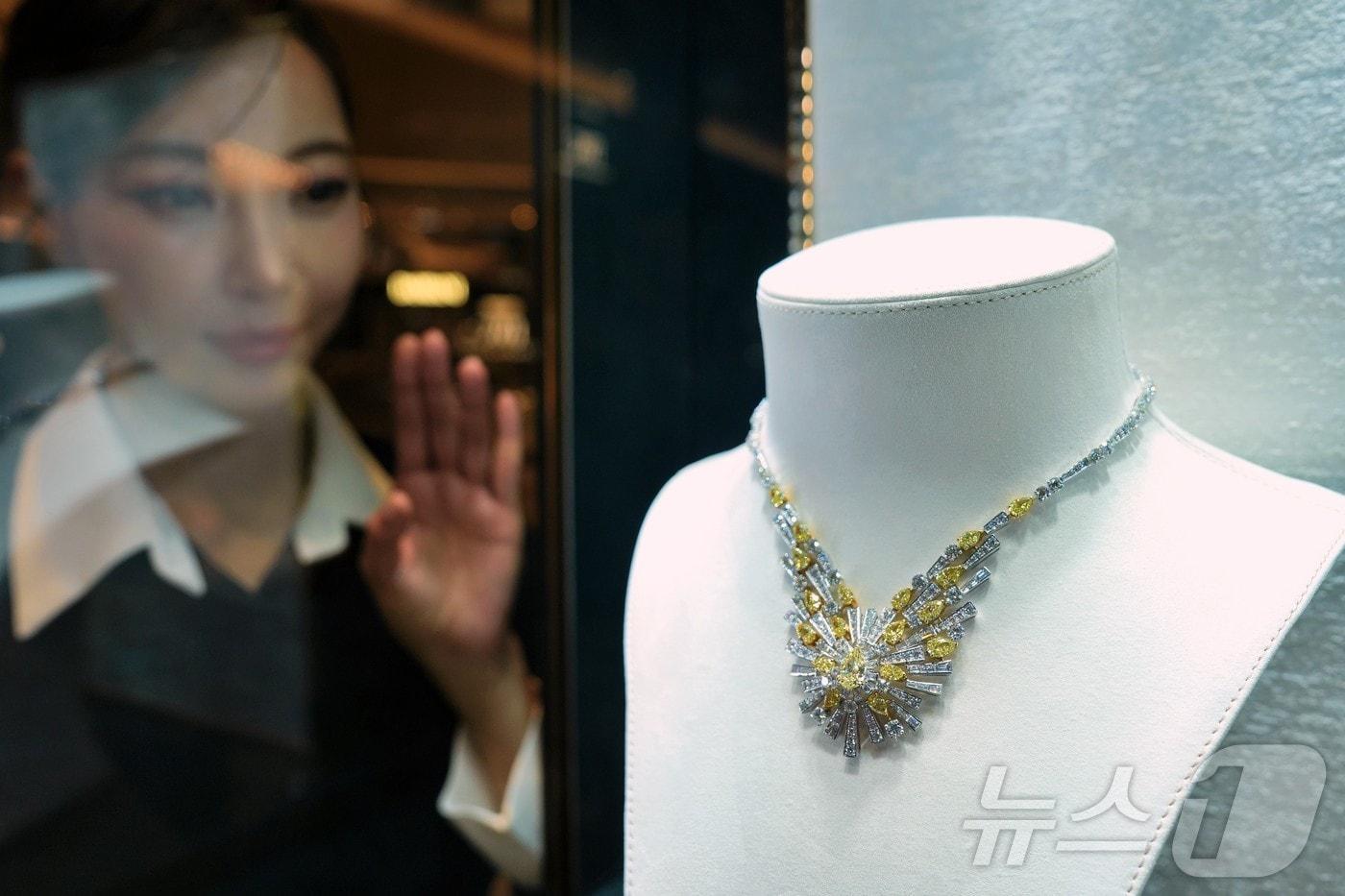 모델이 약 38캐럿의 다이아몬드가 장식된 목걸이를 바라보는 모습. &#40;롯데백화점 제공&#41; 2024.12.1/뉴스1