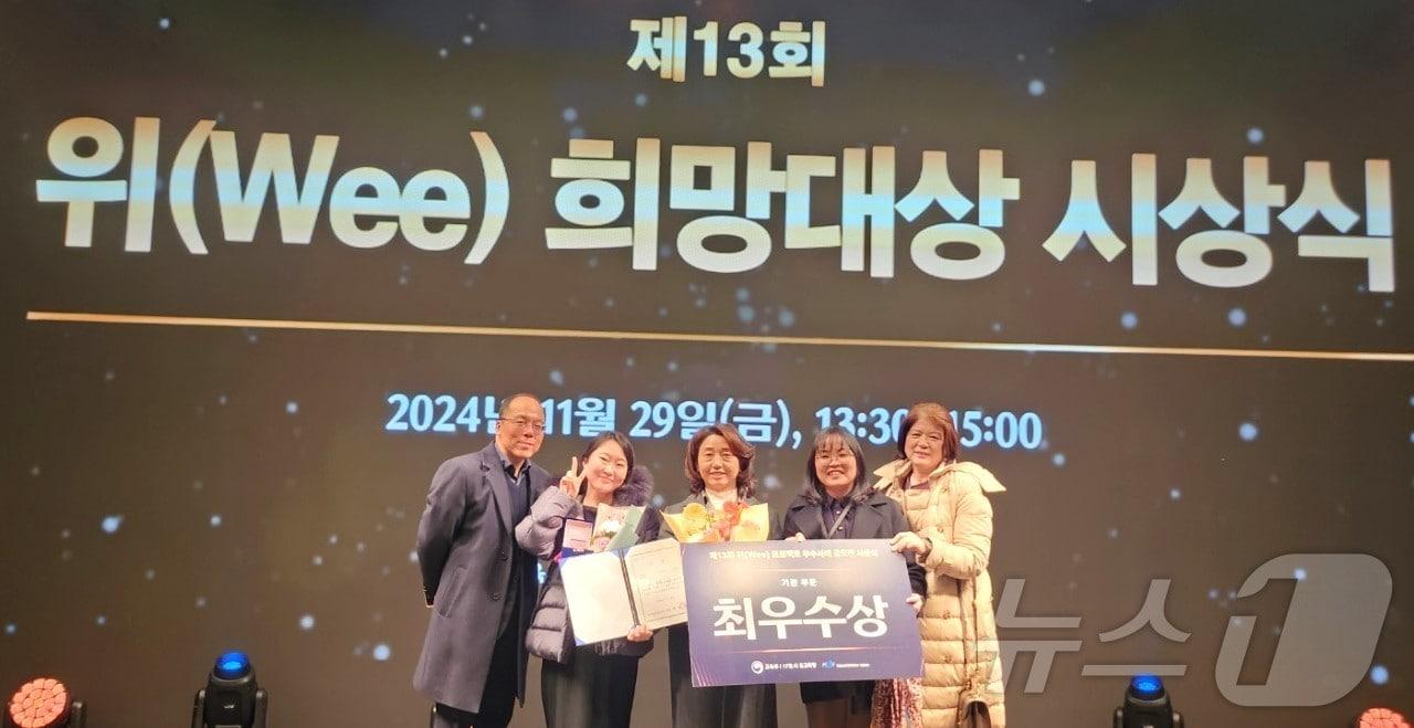 본문 이미지 - 보은교육청 직원들이 '13회 전국 위(Wee) 희망대상'에서 최우수 기관 수상을 기념하는 사진을 찍고 있다.(보은교육청 제공) /뉴스1