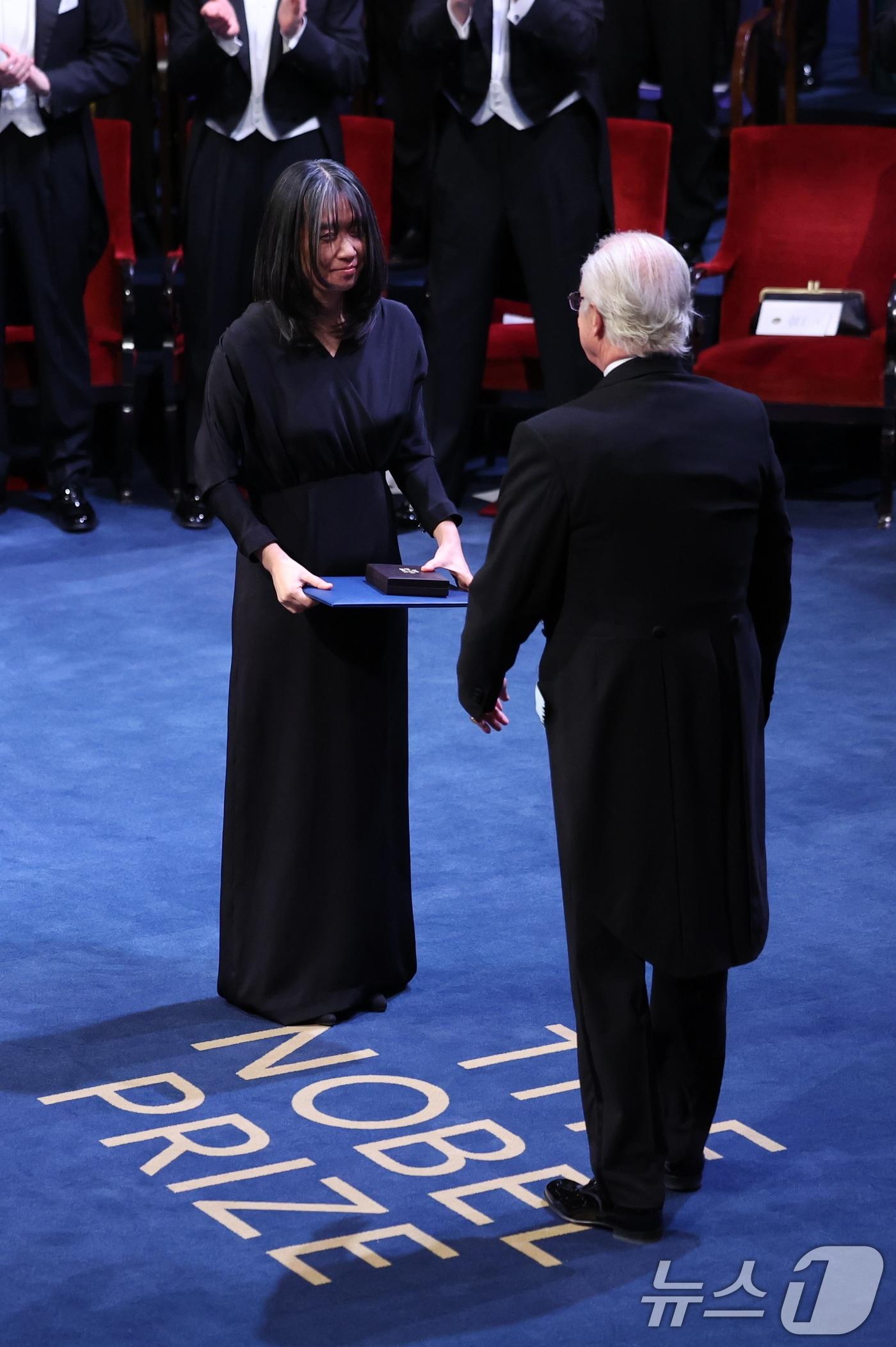 본문 이미지 - 한강이 10일&#40;현지시간&#41; 스웨덴 스톡홀름 콘서트홀에서 열린 2024 노벨상 시상식에서 스웨덴 칼 16세 구스타프 국왕으로부터 노벨 문학상을 수상하고 있다. 2024.12.11/뉴스1 ⓒ News1 박지혜 기자