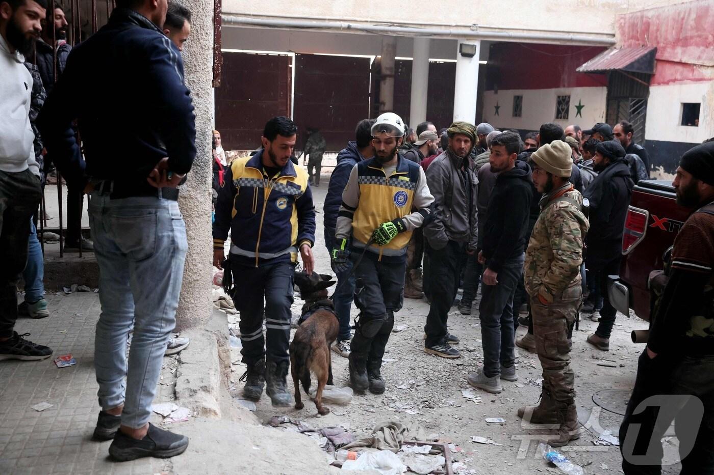 시리아 '하얀 헬멧' 대원과 전문가들이 2024년 12월 9일 다마스쿠스의 사이드나야 교도소에서 숨겨진 지하감옥을 찾고 있다. ⓒ AFP=뉴스1