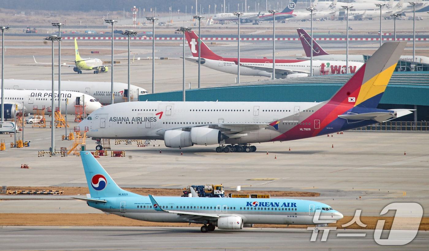 대한항공과 아시아나항공의 합병 절차가 11일 대한항공의 아시아나항공 지분 인수를 끝으로 4년 끝에 마무리 됐다. 사진은 인천공항 계류장 및 활주로에 대한항공과 아시아나 비행기의 모습이 보이고 있다. 2024.12.11/뉴스1 ⓒ News1 이승배 기자