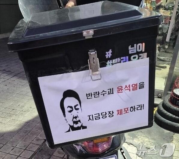 본문 이미지 - 배달 오토바이에 붙은 '윤석열 체포'.(온라인커뮤니티 캡처.2024.12.11/뉴스1