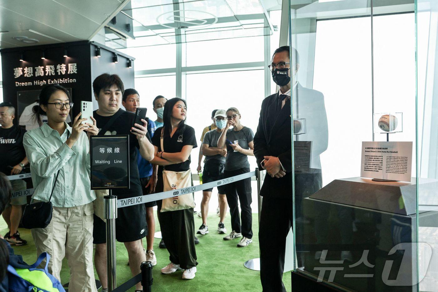 오타니의 사인 공 경매 금액이 1000만 원을 넘어섰다. 사진은 대만 타이베이 101빌딩에서 오타니의 2024시즌 50호 홈런 공을 구경하고 있는 관람객 모습. AFP=뉴스1