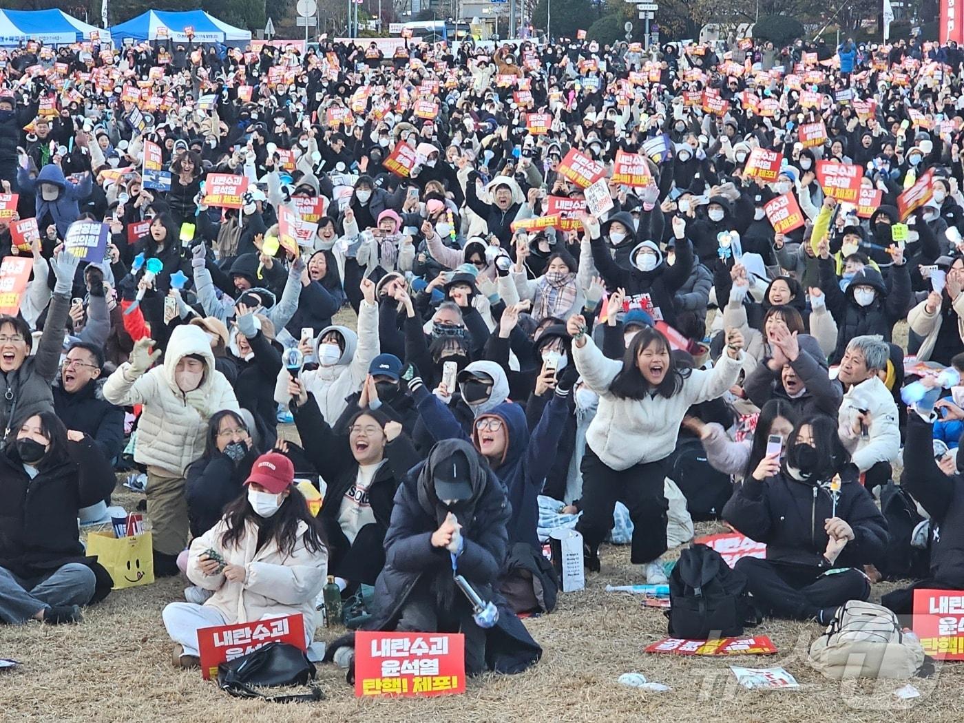 본문 이미지 - 14일 우원식 국회의장이 대통령 탄핵소추안 가결을 선포하자 창원광장에서 이를 지켜보던 시민들이 환호하고 있다. 2024.12.14 ⓒ 뉴스1 박민석 기자