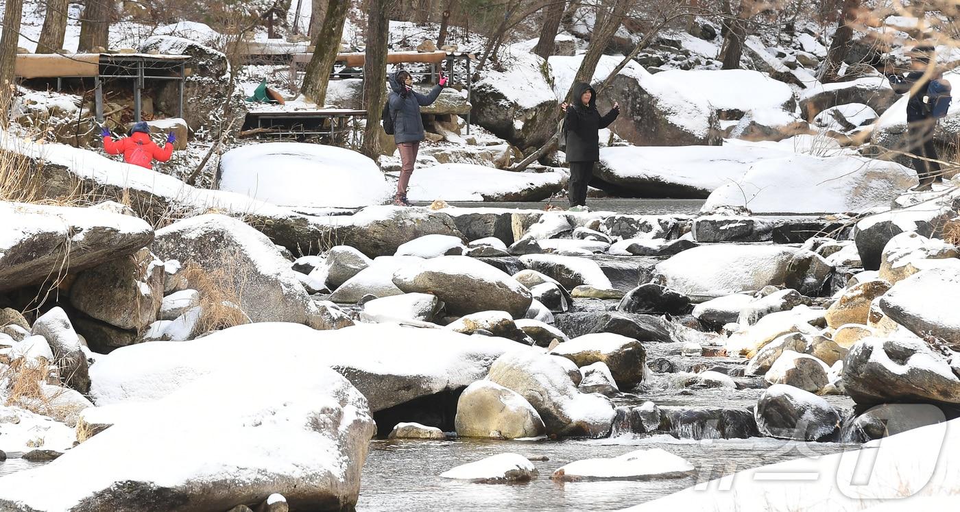 경남 거창군 북상면 남덕유산 자락 월성계곡에 눈이 쌓인 가운데 서출동류 물길을 찾은 등산객들이 겨울 정취를 느끼며 트레킹하고 있다. (거창군 제공) 2024.12.15/뉴스1
