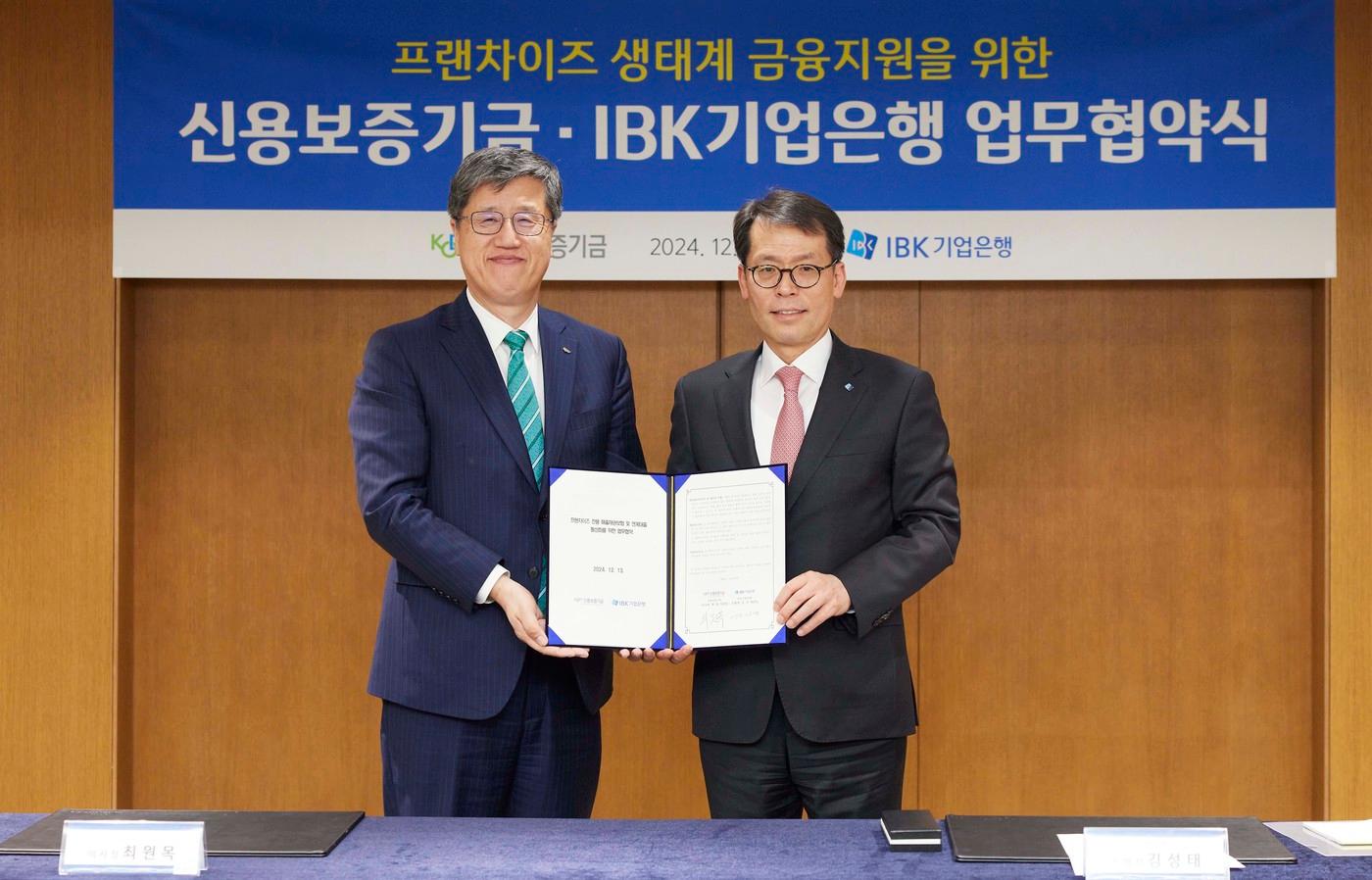 서울 중구 을지로 기업은행 본점에서 열린 업무협약식에서 김성태 IBK기업은행장(오른쪽)과 최원목 신용보증기금 이사장(왼쪽)이 기념촬영을 하고 있는 모습. (IBK기업은행 제공)