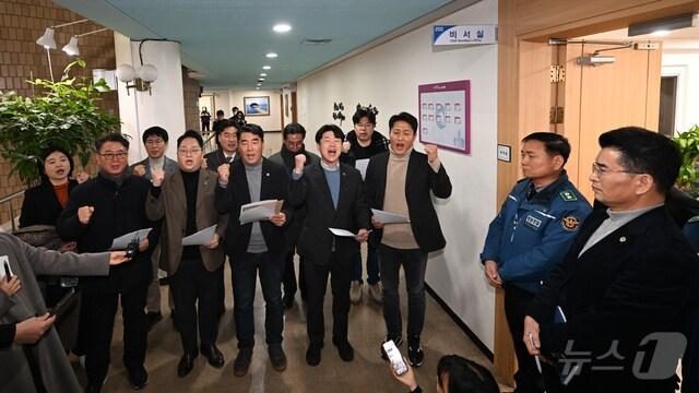 본문 이미지 - 더불어민주당 소속 시의원들이 인천시장 집무실 앞에서 성명서를 발표한 후 구호를 외치고 있다.(독자제공) / 뉴스1