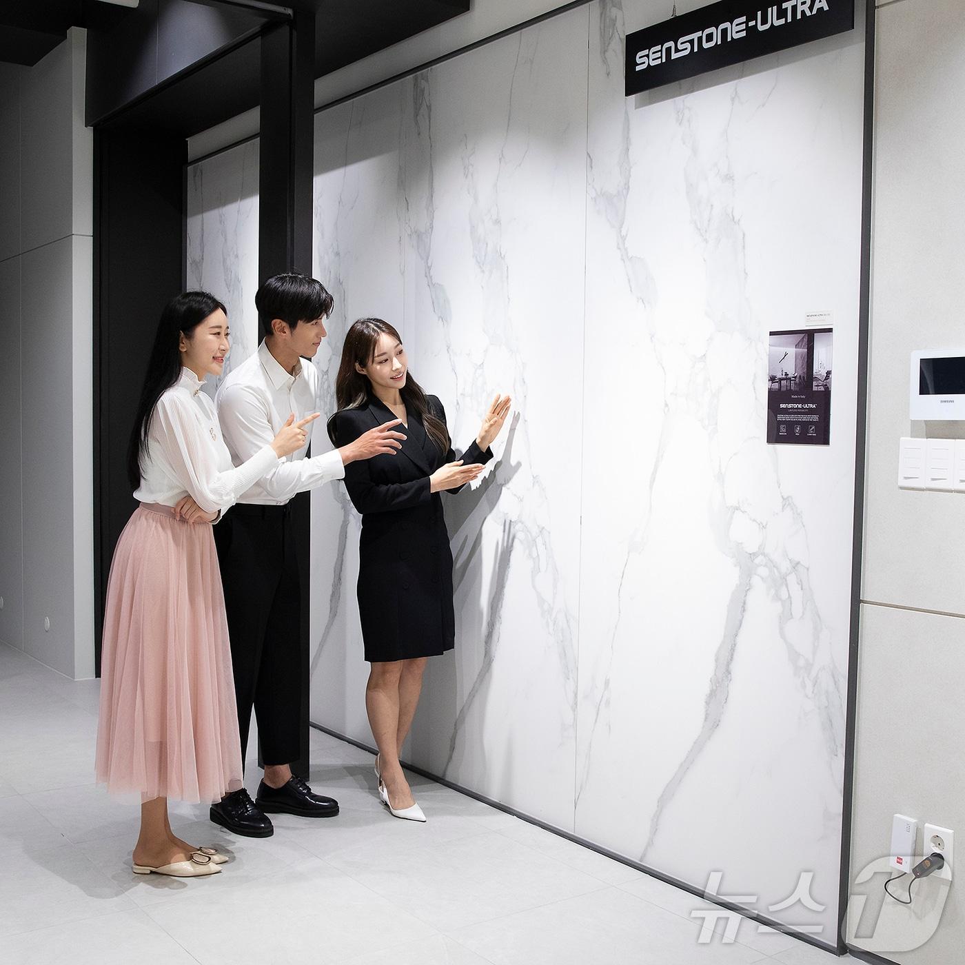 본문 이미지 - 홈씨씨 인테리어 전시장에서 인테리어 스톤 제품인 &#39;센스톤&#39; 시리즈를 살펴보고 있다.&#40;KCC글라스 제공&#41;