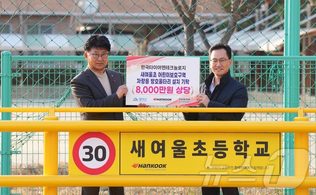 본문 이미지 - 이준길 한국타이어 대전공장장(오른쪽)이 최충규 대전 대덕구청장에게 석봉동 새여울초 어린이보호구역 차량용 방호울타리를 기탁한 뒤 기념촬영을 하고 있다. (한국타이어 제공) /뉴스1  