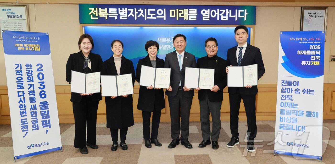 본문 이미지 - 19일 전북자치도청 회의실에서 2036 하계올림픽 전북 유치 홍보대사 위촉식이 열린 가운데 참석자들이 기념 촬영을 하고 있다. 왼쪽부터 박성현 전 양궁 국가대표, 김유정 FIFA 국제심판, 정소영 전 배드민턴 국가대표, 김관영 도지사, 유인탁 전 레슬링 국가대표,  김동문 전 배드민턴 국가대표 순.(전북자치도 제공)/뉴스1
