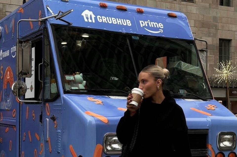 본문 이미지 - 한 여성이 그럽허브 트럭 앞을 지나가며 음료를 마시고 있다. &#40;출처 : 그럽허브&#41; 2024.12.19/